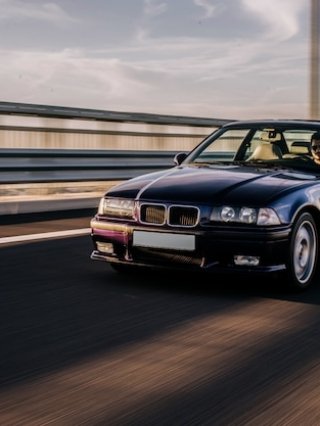 vintage-sedan-car-driving-road_114579-5065